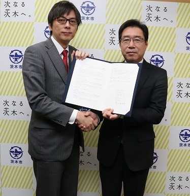 調印後の記念撮影の様子(福岡 洋一 茨木市長様[左]と弊社社長 窪田 耕太郎[右])
